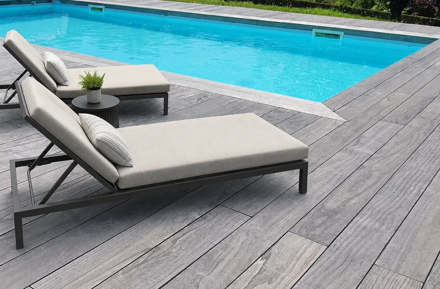 Grey Accoya decking beside a swimming pool with lounge chairs