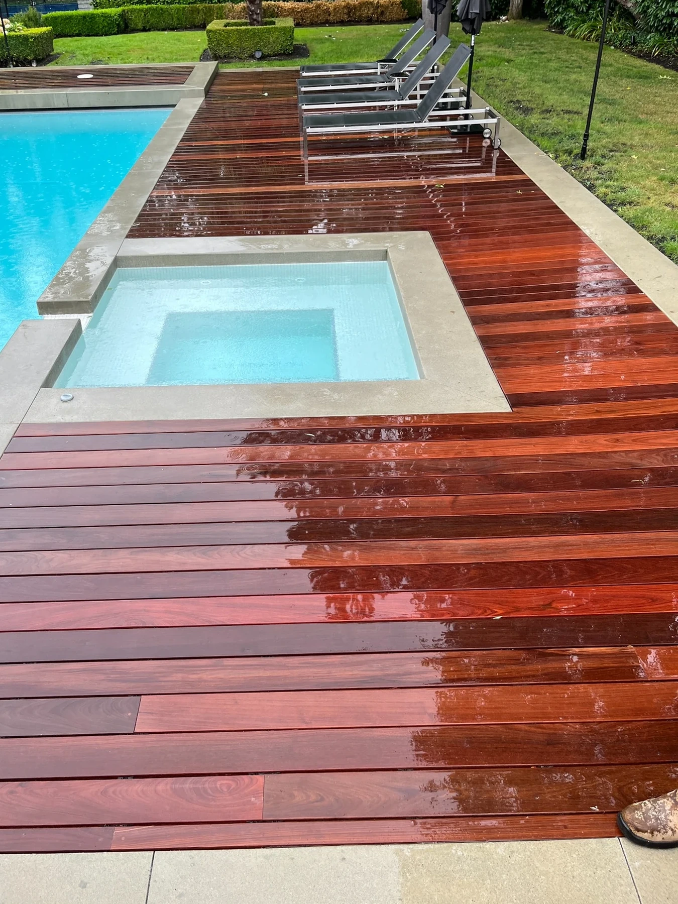 Rich wood decking wrapping a contemporary swimming pool