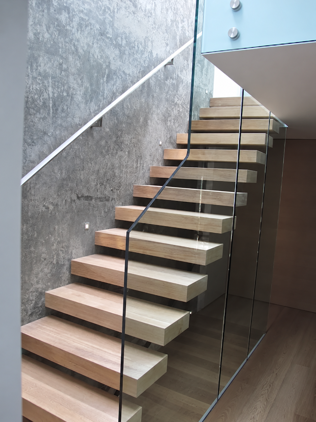 Solid wood floating staircase with glass balustrade